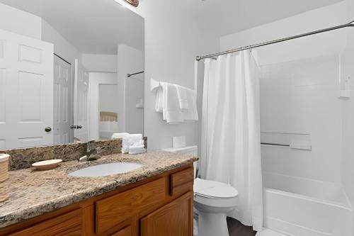 een badkamer met een wastafel, een toilet en een douche bij Quiet house with pool on a Top golf course in Haines City