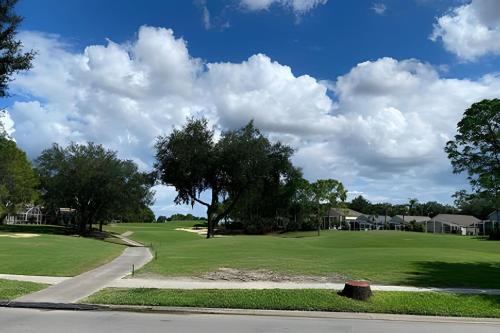 a view of a golf course with trees and houses at Quiet house with pool on a Top golf course in Haines City