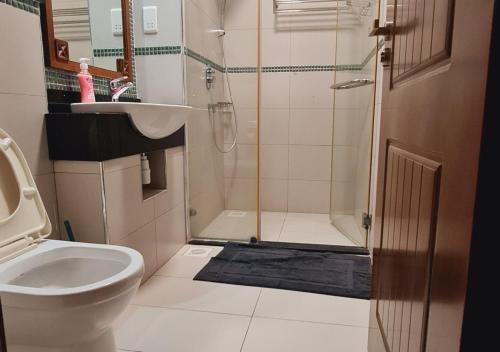 a bathroom with a shower and a toilet and a sink at Haradali Suites 2 Bedroom Beach Apartment - Sultan Palace Beach Resort in Kilifi