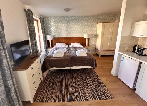 a small bedroom with a bed and a kitchen at Predela 2 Aparthotel in Bansko