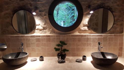 Dos lavabos en un baño con dos espejos en Le Donjon des Combes et son Spa, en Fayence