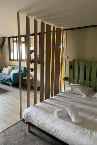 um quarto com uma cama grande e postes de madeira em Bel appartement moderne au coeur de Grenoble em Grenoble