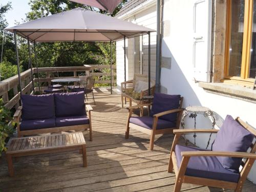 a porch with chairs and an umbrella and a table at Holiday home with swimming pool in Corr ze in Auriac