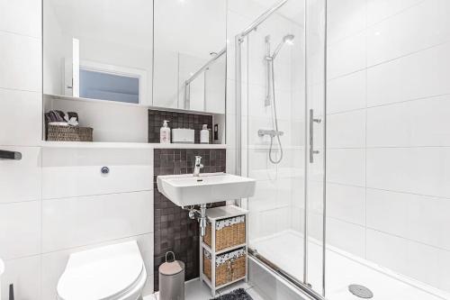 uma casa de banho branca com um lavatório e um chuveiro em High Spec 2 Bed, 2 Bath, Wi-Fi, Balcony em Hemel Hempstead