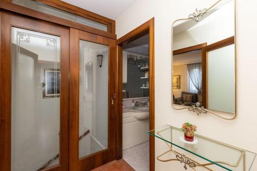 bagno con lavandino, servizi igienici e specchio di Villa Nidia a 5 minuti dal mare 