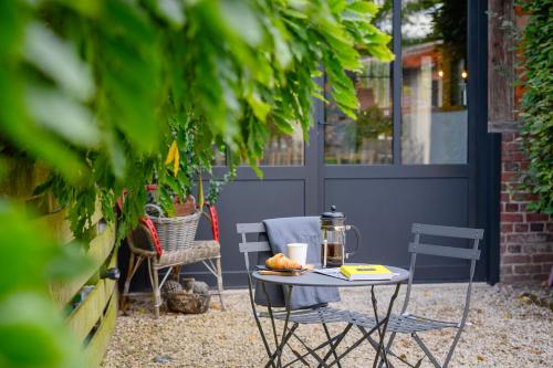a small table and chairs on a patio at ATELIER 19 Maison d'Hôtes in Varesnes