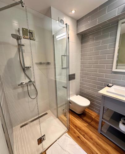 a bathroom with a glass shower and a toilet at Predela 2 Aparthotel in Bansko
