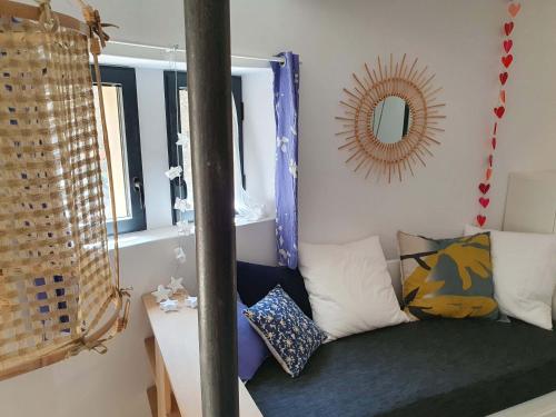 a small room with a couch and a mirror at L'Exquishette de Lourmarin, un nid sur les toits. in Lourmarin