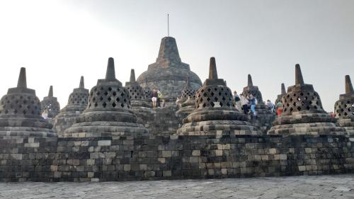 a group of buddhist temples on a wall at Genthong Homestay in Borobudur