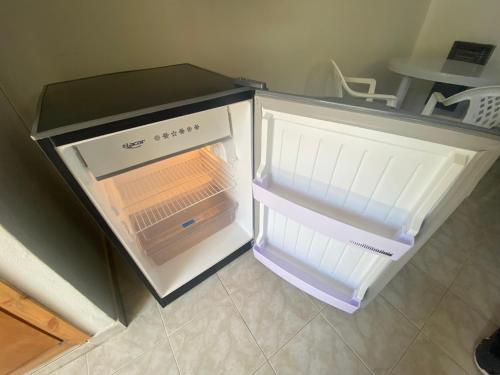 Un refrigerador vacío con la puerta abierta en una cocina. en Lomita Gesell, en Villa Gesell