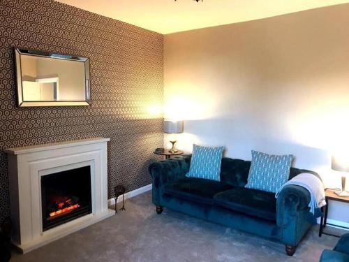 a living room with a couch and a fireplace at Beautiful holiday flat in Alnwick in Alnwick