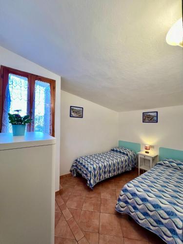 a bedroom with two beds and a window at Case Vacanze Maestrale in Fetovaia