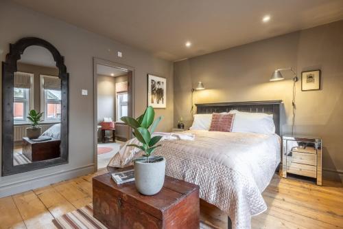 a bedroom with a bed and a plant on a table at Norfolk House 2 in Heacham