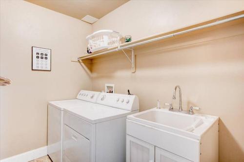 a laundry room with a washing machine and a sink at Central LocationGarage Large andFenced Backyard in Orem