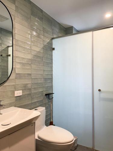 a bathroom with a toilet and a sink and a mirror at Good Trip 菇憩南門 包棟民宿 in Hengchun