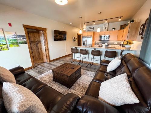 a living room with a couch and a kitchen at Happy Trails Condo in Columbia Falls