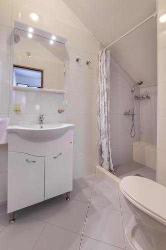 a white bathroom with a sink and a shower at Villa Cera Dignano in Vodnjan