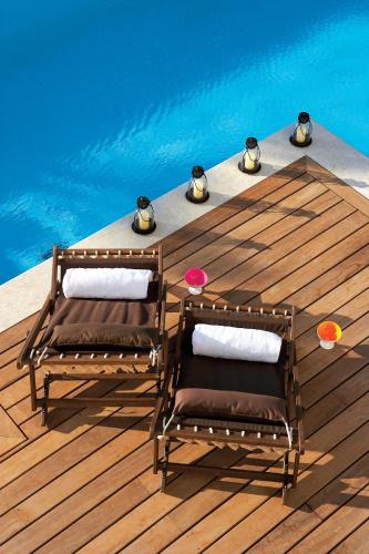 a table and chairs on a wooden deck next to a pool at Rodos Palace Hotel in Ixia