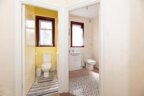 a bathroom with a toilet and a sink at Barking Road Comfy House in London