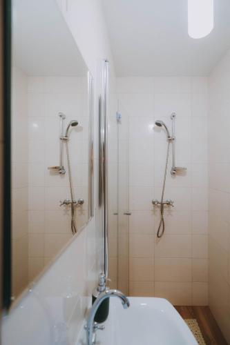 a bathroom with a shower and a sink at Domek Leśny nad Tanwią in Koszele