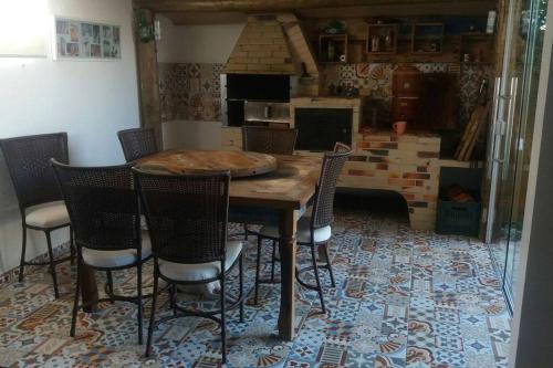 una mesa de madera y sillas en la cocina en Linda casa de praia 5km Beto Carrero - Gravatá. 300 metros da praia!!, en Navegantes
