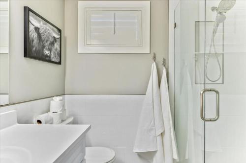 a white bathroom with a toilet and a shower at King Bed Modern Living Room Cozy Backdoor Patio in Salt Lake City