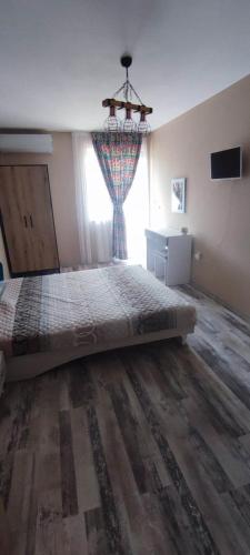 a bedroom with a large bed with a window at Узунови Апартамент Трявна леик in Tryavna