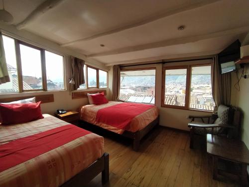 Habitación de hotel con 2 camas y ventanas en La Casa de Mayte, en Cusco