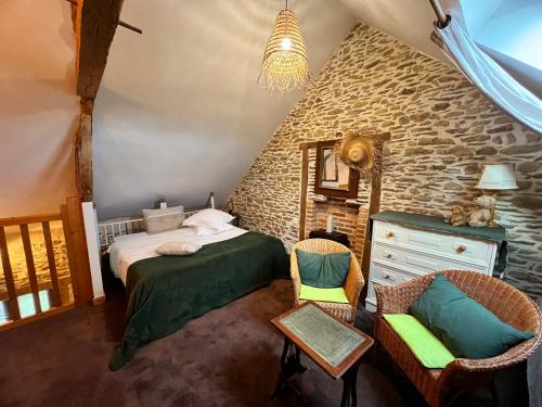 um quarto com uma cama e cadeiras num quarto em Maison d'hôtes et gîte au Manoir de la Haute Pilais em Chantepie