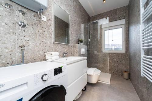 ein Badezimmer mit einem weißen Waschbecken und einer Toilette in der Unterkunft Mina stunning sea view apartment in Novalja