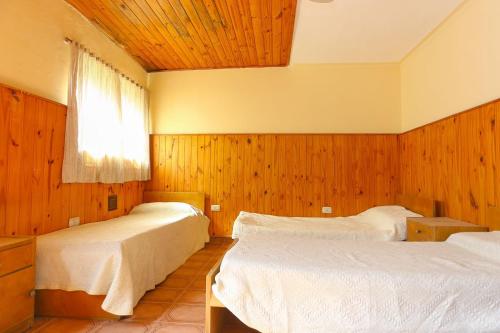 a bedroom with two beds and a window at Amplia Quinta Familiar en Sauce Viejo in Sauce Viejo