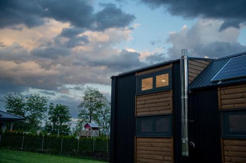 a black house with windows and a cloudy sky at Tiny House nähe Millstättersee gemütlich & autark in Oberkolbnitz