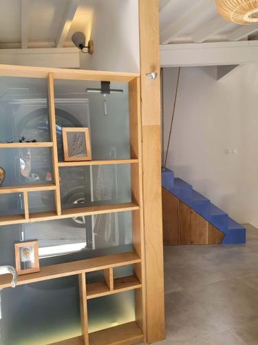 a book shelf in a room with a staircase at L'Exquishette de Lourmarin, un nid sur les toits. in Lourmarin