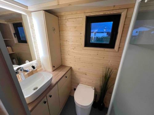 łazienka z umywalką, toaletą i oknem w obiekcie Tiny House nähe Millstättersee gemütlich & autark w mieście Oberkolbnitz