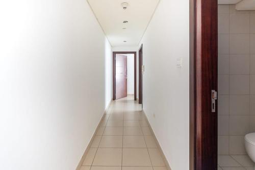 a hallway of a bathroom with a toilet and a sink at Frank Porter - Burj Views in Dubai