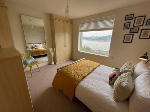 Un dormitorio con una cama grande y una ventana. en Beautiful 2 bedroom apartment with estuary views, en Deganwy