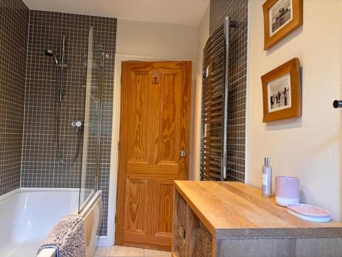 a bathroom with a tub and a sink and a shower at Beautiful 2 bedroom apartment with estuary views in Deganwy