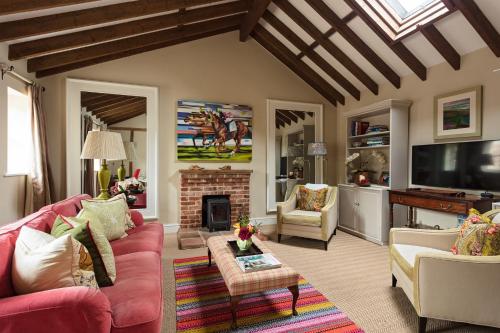 a living room with a red couch and a fireplace at The Old Dairy in Holt