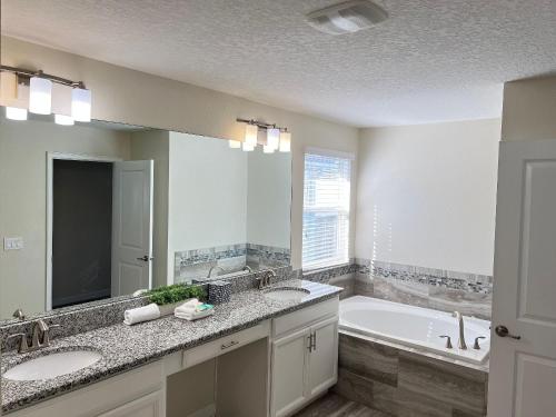 a bathroom with two sinks and a bath tub at Wonderful home close to disney & universal in Kissimmee