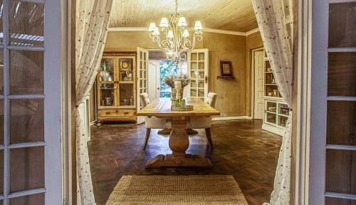 a dining room with a table and a chandelier at Petite Provence B&B in Ballito