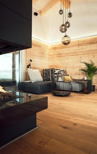 a living room with a black couch and wooden walls at VÜ Terrassen-Chalets in Münchberg