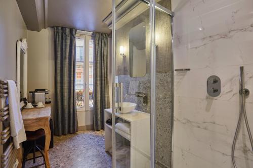 a bathroom with a sink and a glass shower at Le Robinet d'Or Paris Canal Saint Martin in Paris