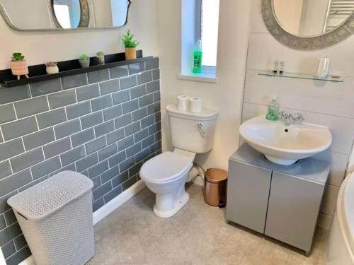 a bathroom with a white toilet and a sink at 3 Bed Residential home - 5 mins from M4 in Port Talbot