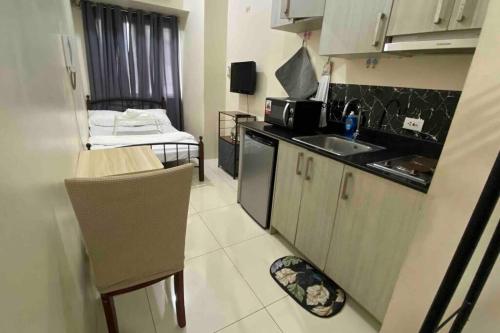 a small kitchen with a sink and a microwave at Minimalist Studio Unit near PGH, DLSU, CSB in Manila