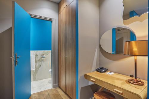 a bathroom with a wooden table and a blue door at Le Robinet d'Or Paris Canal Saint Martin in Paris