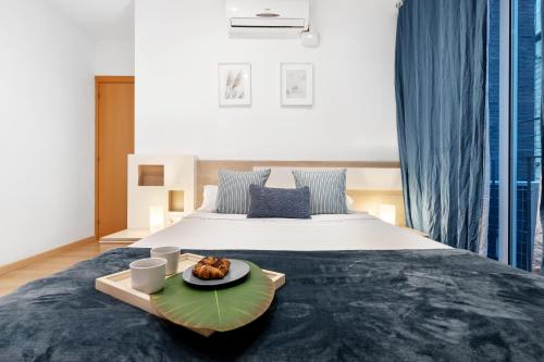 RECENTLY RENOVATED 2 BEDROOM APARTMENT IN EIXAMPLE في برشلونة: سرير مع صينية عليها صحن من الطعام