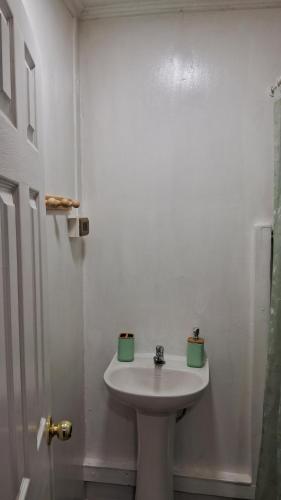 Un lavabo blanco en un baño con dos tazas verdes. en OHiggins 1087, en Iquique