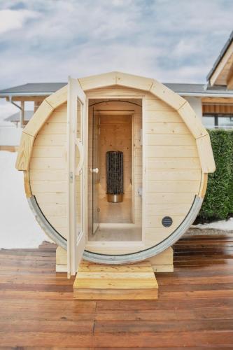 a round wooden sauna on a wooden deck at VÜ Terrassen-Chalets in Münchberg