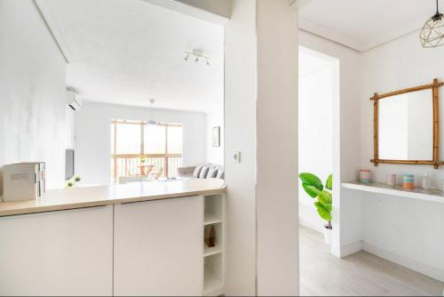 a white kitchen with white cabinets and a counter at Apartamento amplio con 4 habitaciones y 2 baños - Great apartment with 4 rooms - 2 baths in Seville