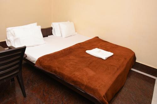 a bed with two white towels on top of it at Hotel Park, Thiruvannamalai in Tiruvannāmalai